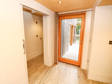 A hallway with wooden flooring and a glass door leading outside at Lodge 6 in Corfe Castle