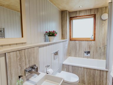 A bathroom with a sink toilet bathtub and a window at Lodge 12 in Corfe Castle
