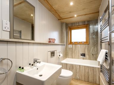 A bathroom with a sink toilet bathtub and towel rack at Lodge 13 in Corfe Castle