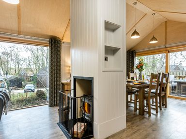 A dining room with a fireplace and dining table at Lodge 15 Corfe Castle