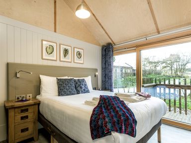 A bedroom with a bed and window at Lodge 15 Corfe Castle