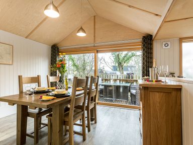 A dining room with a large table and chairs at Lodge 17 in Corfe Castle