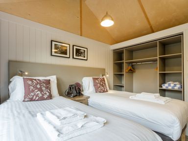 A bedroom with twin beds and a wardrobe at Lodge 17 in Corfe Castle