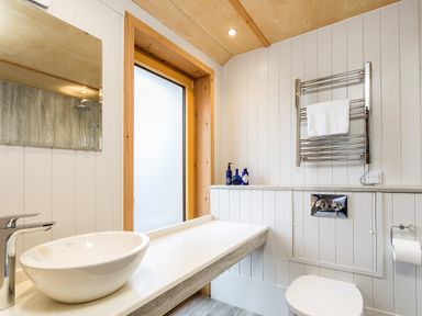 A bathroom with sink, toilet, and towel rack at Lodge 17 in Corfe Castle