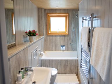 A bathroom with a bathtub and sink at Lodge 19 in Corfe Castle