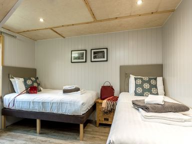 A bedroom with two beds and decorative items at Lodge 19 in Corfe Castle