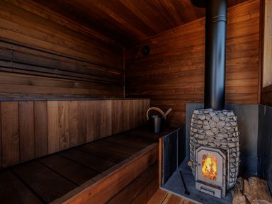 A sauna with wood stove and bench at Lodge 21 in Corfe Castle