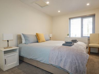 A bedroom with a double bed and bedside tables with lamps at Falcon House in Tintagel