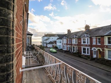A street view with houses and a green car parked near the seaside at Elkhorn in Southwold
