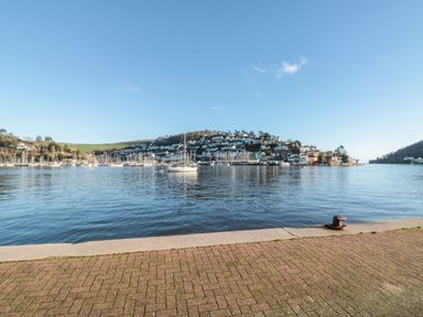 A waterfront view with boats on the water and houses on a hillside at The Bolthole in Dartmouth
