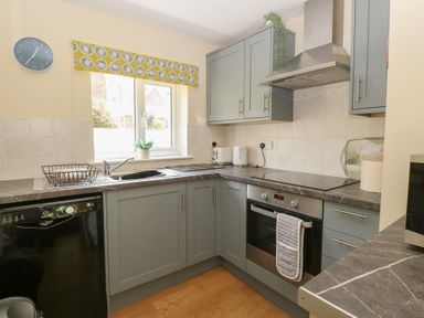 A kitchen with various appliances and cabinets at 15 The Dell in Mundesley