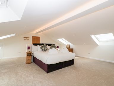 A bedroom with a double bed pillows bedside tables and skylight windows at Bilsham Meadows in Aust