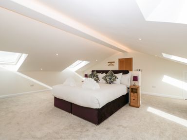 A bedroom with a double bed pillows bedside tables and skylights at Bilsham Meadows in Aust