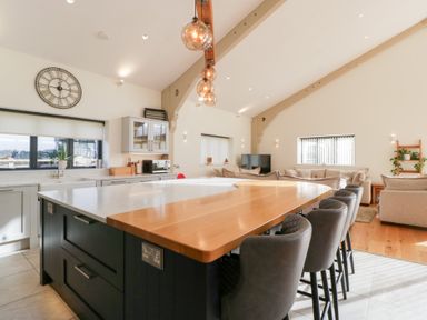 A kitchen with an island and stools at Bilsham Meadows in Aust