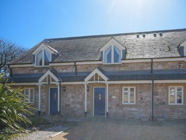A stone house with two blue doors and dormer windows at Smugglers Cove 7 in Beadnell