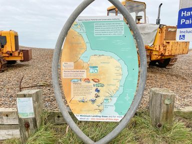 A map sign showing the Eastern Inshore Fisheries and Conservation Authority area with an old yellow Fiat tractor in the background at Timbers in Weybourne