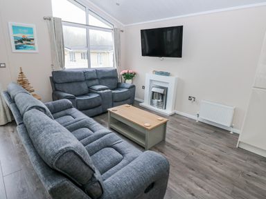 A living room with a sofa and coffee table at Dono's Lodge, Stepaside near Kilgetty, Heritage Park