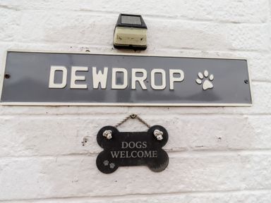 A nameplate and welcome sign mounted on a wall at 22 Longstone Park Beadnell