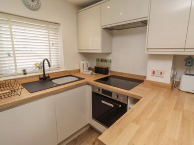 A kitchen featuring a sink, cooktop, and oven at 22 Longstone Park Beadnell