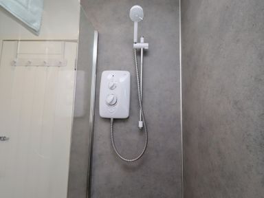 A shower with a shower head and control unit at 22 Longstone Park Beadnell