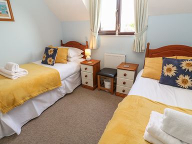 A bedroom with two single beds and bedside tables at Bumbles in Padstow