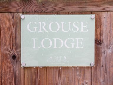 A sign reading Grouse Lodge mounted on wooden boards at Riggs Head Farm