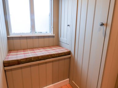 A small corner with a built-in bench under a window and built-in cupboards with knobs at Grouse Lodge in Seamer North Yorkshire
