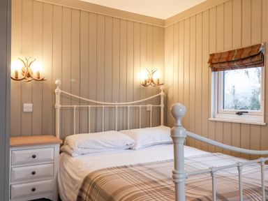 A bedroom with a bed nightstand and window at Grouse Lodge in Seamer North Yorkshire
