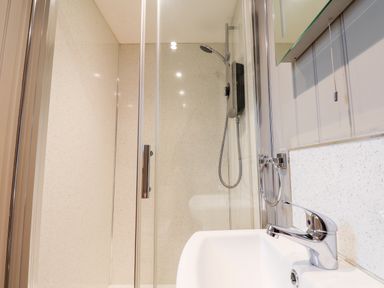 A bathroom with a shower enclosure and a sink with a faucet at Grouse Lodge in Seamer North Yorkshire