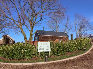 A driveway with gravel and green shrubs beside a signpost pointing to Sunset Retreat and Foxes Den at Foxes Den in Seamer North Yorkshire