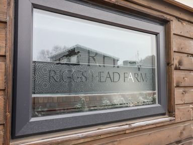 A window with text riggs head farm on a wooden building at Sunset Retreat in Seamer North Yorkshire