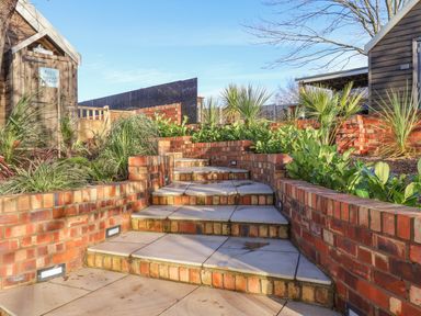 Outdoor brick staircase with plants and wooden sheds at Sunset Retreat in Seamer North Yorkshire