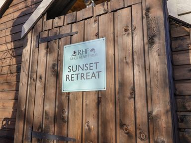 A wooden door with a sign reading Sunset Retreat at Riggs Head Farm