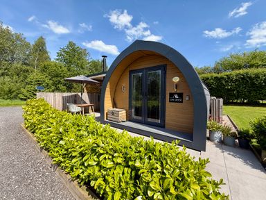 A cabin entrance with greenery at Oh Deer in Ashbourne