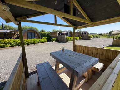 An outdoor seating area with a table and benches at Oh Deer in Ashbourne