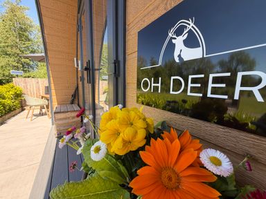 An outdoor area with flowers and a sign at Oh Deer in Ashbourne