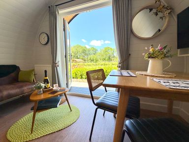 A cozy seating area with a table overlooking a garden at Oh Deer in Ashbourne