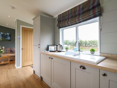 A kitchen with a sink under a window and a toaster kettle on the counter at Willow Lodge in Winthorpe near Newark-On-Trent