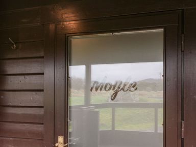 A wooden door with frosted glass and the word Moyle on the glass at Moyle Lodge in Dalbeattie