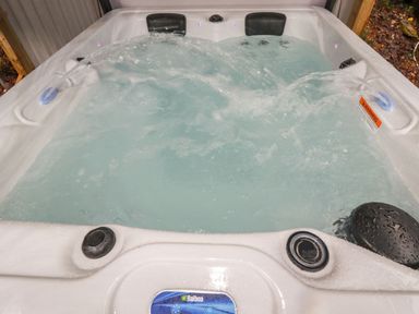 An outdoor hot tub with water jets and headrests at The View in Cardinham