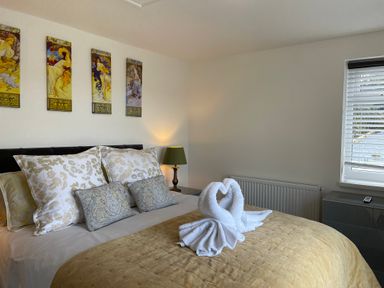 A bedroom with a bed with pillows and towel swans on the bed at The View in Cardinham