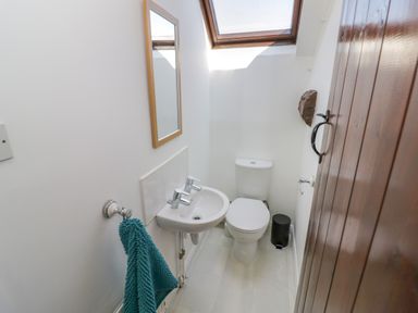 A small bathroom with a toilet sink mirror towel and skylight at The Paddock in New Yatt near Witney