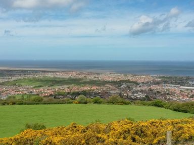 A coastal town with houses fields and ocean in the background at Cariad Bach in Gwaenysgor near Prestatyn