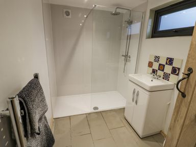 A bathroom with a walk-in shower a white sink with cabinet and a towel hanging on a rail at Willow in Dunchurch