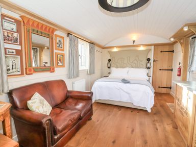 A bedroom with a bed and leather sofa and Egyptian themed decor at The Egyptologist in Bolton Percy near Tadcaster