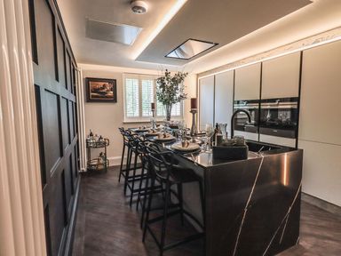 A kitchen with a large island and bar stools set for dining at Whisk Away Cottage Greystoke near Troutbeck Near Penrith