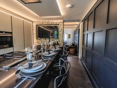 A kitchen with a long island counter set with plates glasses and napkins at Whisk Away Cottage Greystoke near Troutbeck Near Penrith