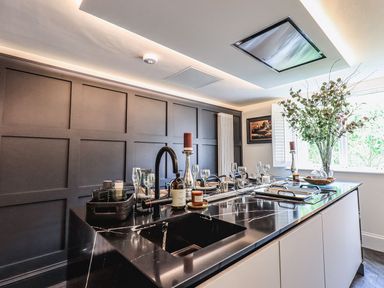 A kitchen island with a sink faucet and set table in a room with a window at Whisk Away Cottage Greystoke near Troutbeck Near Penrith