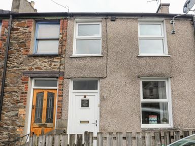 A front view of two adjacent terraced houses with different exterior wall finishes and windows at 5 Thomas Street in Llanberis