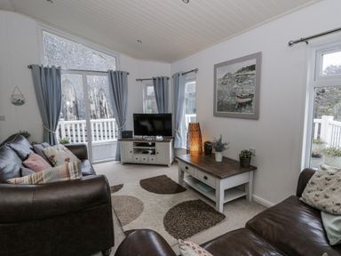 A living room with a television and sofa at Seacroft Stepaside near Kilgetty